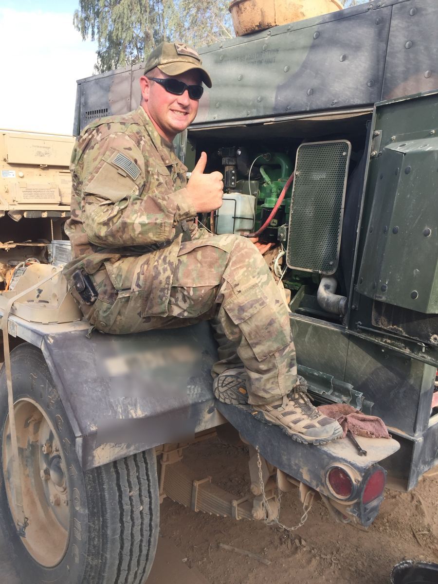 Ben Chambers in uniform servicing a generator during his National Guard deployment