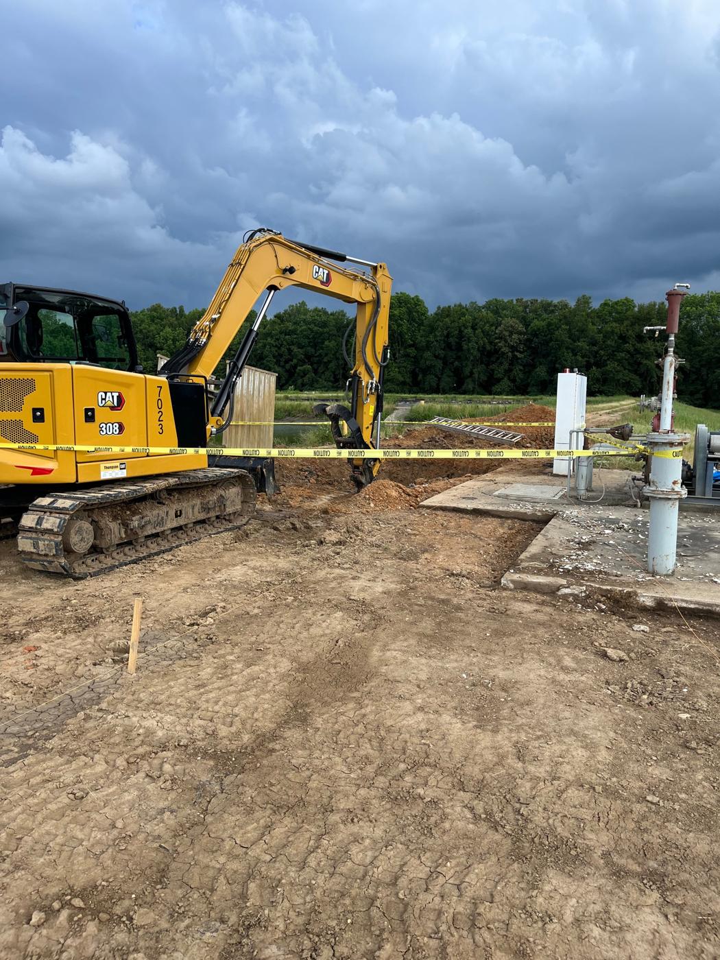 Excavating for new piping beside the existing pump area