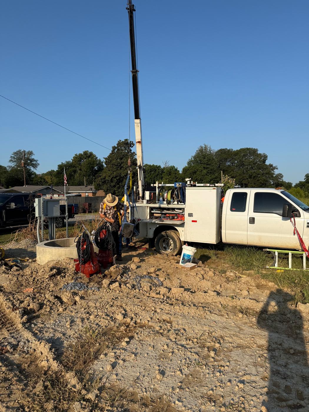 Submersible pumps staged beside the wet well, with the crane ready to set them