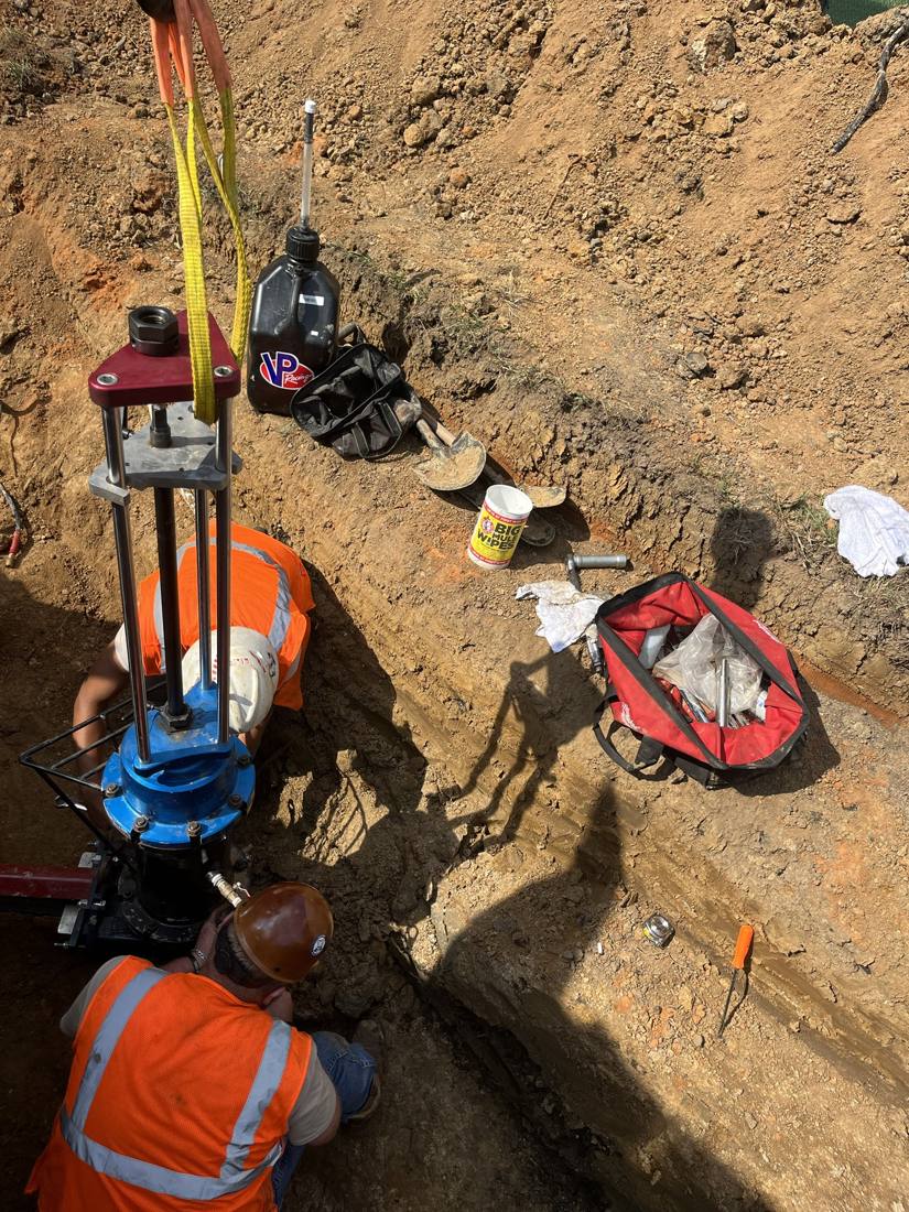 Crew setting an insertion valve in the trench