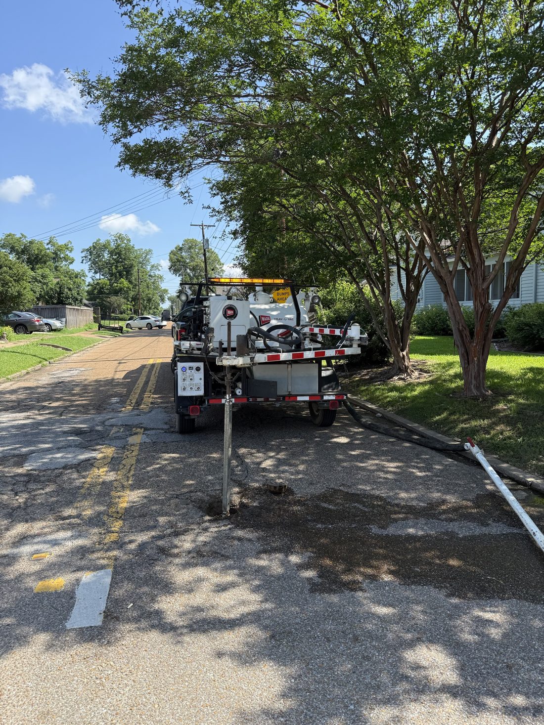 Valve exercising on a city street with a trailer-mounted Wachs unit and the valve operator set over a valve box